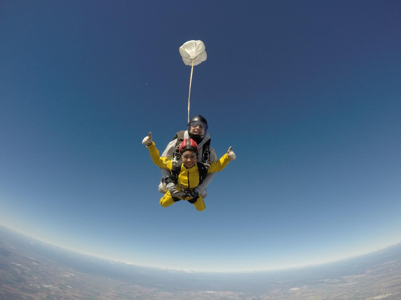 Priyanka skydiving, giving a thumbs-up mid-jump